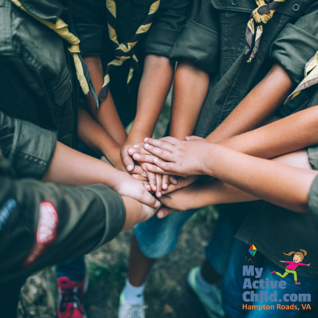 Scouts with their hands stacked together in a circle